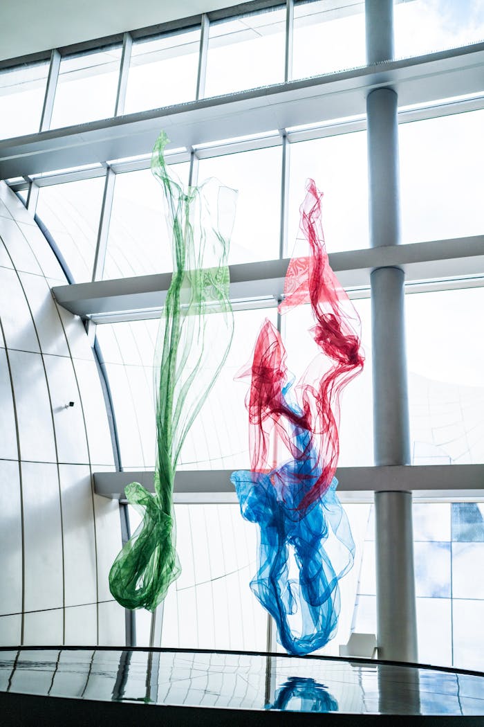 our-experience Vibrant fabric sculptures in a modern architectural interior with natural light.