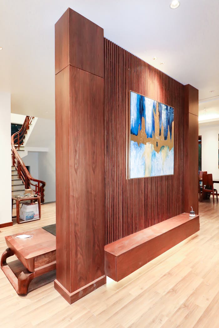 Modern interior featuring a wooden accent wall with abstract blue and gold art. Bright and spacious layout.