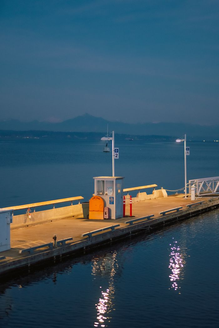Tranquil evening view of a pier with soft lighting on the calm sea.